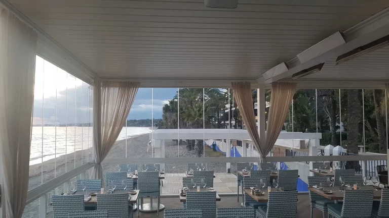 Calefactores de exterior en la terraza acristalada de un restaurante de playa en Marbella