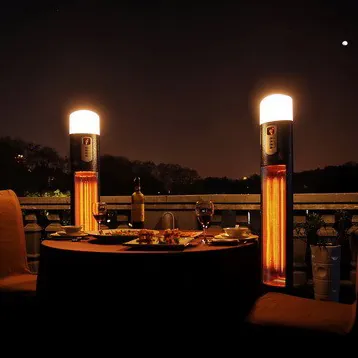 Calefactores de pie con lámpara encendidos de noche en la terraza del restaurante El Jardín de Diana
